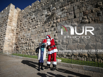 In Jerusalem, Israel, on December 19, 2024, Christian Palestinian Issa Kassissieh, dressed as Santa Claus, greets the public from the old ci...