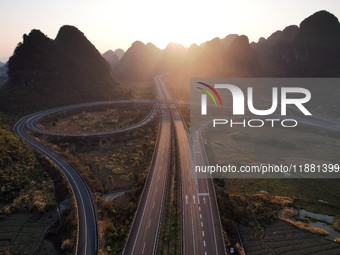 Vehicles drive on the Hongling interconnecting section of an expressway in Daliang town, Rongan County, Liuzhou city, South China's Guangxi...