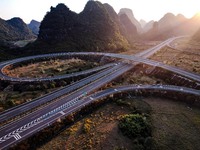 Vehicles drive on the Hongling interconnecting section of an expressway in Daliang town, Rongan County, Liuzhou city, South China's Guangxi...