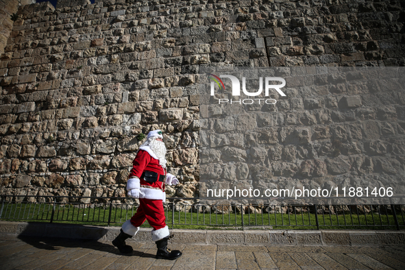 In Jerusalem, Israel, on December 19, 2024, Christian Palestinian Issa Kassissieh, dressed as Santa Claus, greets the public from the old ci...