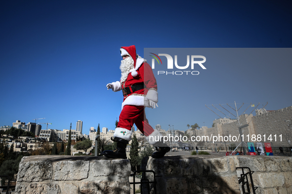 In Jerusalem, Israel, on December 19, 2024, Christian Palestinian Issa Kassissieh, dressed as Santa Claus, greets the public from the old ci...