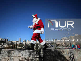 In Jerusalem, Israel, on December 19, 2024, Christian Palestinian Issa Kassissieh, dressed as Santa Claus, greets the public from the old ci...