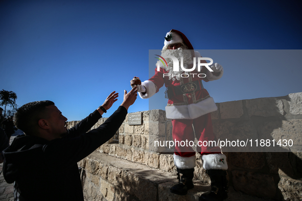 In Jerusalem, Israel, on December 19, 2024, Christian Palestinian Issa Kassissieh, dressed as Santa Claus, greets the public from the old ci...