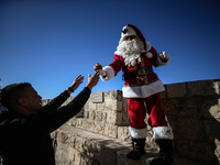 In Jerusalem, Israel, on December 19, 2024, Christian Palestinian Issa Kassissieh, dressed as Santa Claus, greets the public from the old ci...