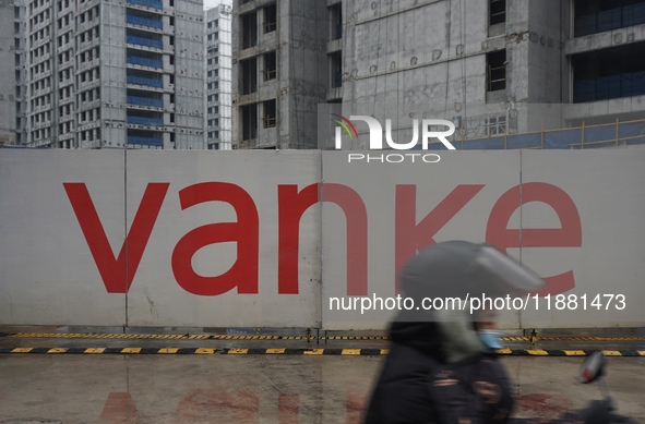 A pedestrian passes a newly built commercial housing complex of China Vanke in Hangzhou, Zhejiang province, China, on December 19, 2024. 