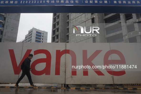 A pedestrian passes a newly built commercial housing complex of China Vanke in Hangzhou, Zhejiang province, China, on December 19, 2024. 