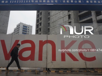 A pedestrian passes a newly built commercial housing complex of China Vanke in Hangzhou, Zhejiang province, China, on December 19, 2024. (