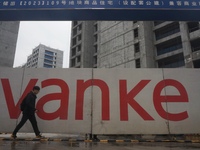 A pedestrian passes a newly built commercial housing complex of China Vanke in Hangzhou, Zhejiang province, China, on December 19, 2024. (