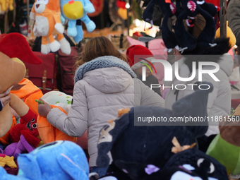 A colorful display of plush toys is at a market in Grafing, Bavaria, Germany, on December 15, 2024. Children browse the market atmosphere. (