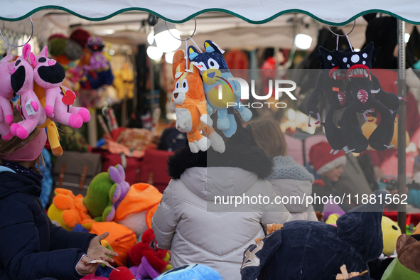 A colorful display of plush toys is at a market in Grafing, Bavaria, Germany, on December 15, 2024. Children browse the market atmosphere. 