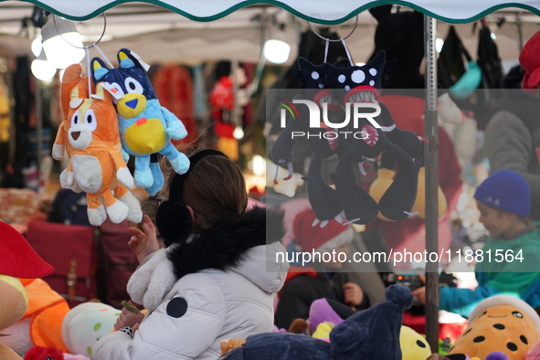 A colorful display of plush toys is at a market in Grafing, Bavaria, Germany, on December 15, 2024. Children browse the market atmosphere. 