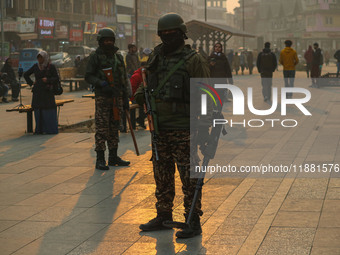 Indian security personnel stand guard along a road in Srinagar, Jammu and Kashmir, on December 19, 2024. Indian security forces kill five mi...