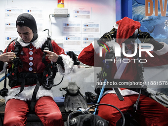 A diver dressed as Santa Claus prepares for a feeding performance to celebrate Christmas at Sea Life Bangkok Ocean World aquarium in Bangkok...