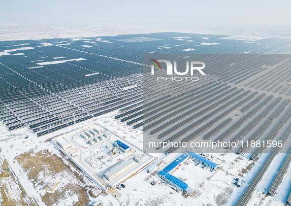 Operation and maintenance personnel clean snow on photovoltaic modules in the 100,000-kilowatt photovoltaic power generation project area of...