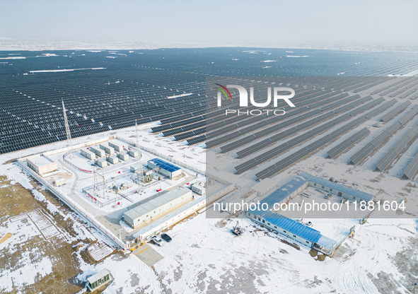 Operation and maintenance personnel clean snow on photovoltaic modules in the 100,000-kilowatt photovoltaic power generation project area of...