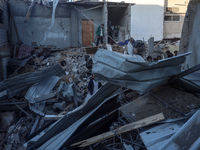 Palestinians inspect the site of an Israeli airstrike on a house amid the ongoing conflict between Israel and Hamas in Al-Maghazi, central G...