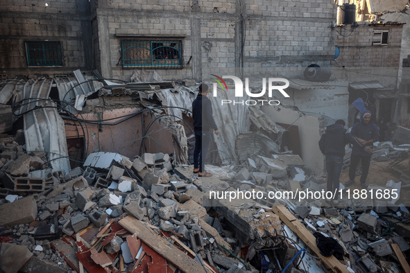 Palestinians inspect the site of an Israeli airstrike on a house amid the ongoing conflict between Israel and Hamas in Al-Maghazi, central G...