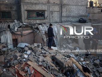 Palestinians inspect the site of an Israeli airstrike on a house amid the ongoing conflict between Israel and Hamas in Al-Maghazi, central G...