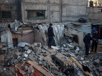 Palestinians inspect the site of an Israeli airstrike on a house amid the ongoing conflict between Israel and Hamas in Al-Maghazi, central G...