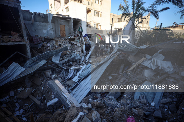 Palestinians inspect the site of an Israeli airstrike on a house amid the ongoing conflict between Israel and Hamas in Al-Maghazi, central G...