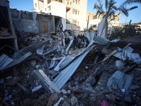 Palestinians inspect the site of an Israeli airstrike on a house amid the ongoing conflict between Israel and Hamas in Al-Maghazi, central G...