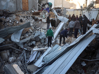 Palestinians inspect the site of an Israeli airstrike on a house amid the ongoing conflict between Israel and Hamas in Al-Maghazi, central G...