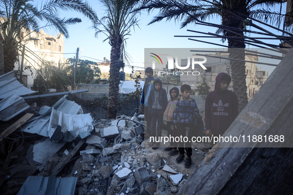 Palestinians inspect the site of an Israeli airstrike on a house amid the ongoing conflict between Israel and Hamas in Al-Maghazi, central G...