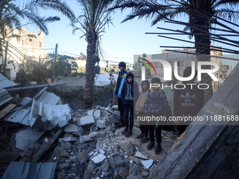 Palestinians inspect the site of an Israeli airstrike on a house amid the ongoing conflict between Israel and Hamas in Al-Maghazi, central G...