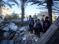 Palestinians inspect the site of an Israeli airstrike on a house amid the ongoing conflict between Israel and Hamas in Al-Maghazi, central G...