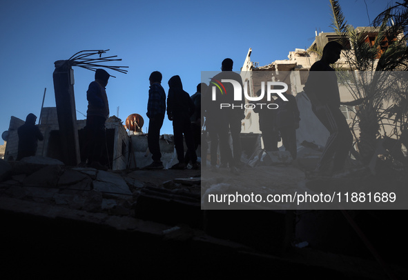 Palestinians inspect the site of an Israeli airstrike on a house amid the ongoing conflict between Israel and Hamas in Al-Maghazi, central G...