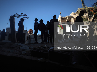 Palestinians inspect the site of an Israeli airstrike on a house amid the ongoing conflict between Israel and Hamas in Al-Maghazi, central G...