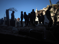 Palestinians inspect the site of an Israeli airstrike on a house amid the ongoing conflict between Israel and Hamas in Al-Maghazi, central G...