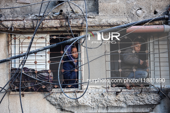 Palestinians inspect the site of an Israeli airstrike on a house amid the ongoing conflict between Israel and Hamas in Al-Maghazi, central G...