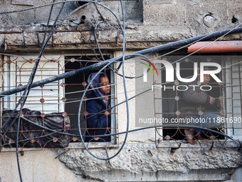 Palestinians inspect the site of an Israeli airstrike on a house amid the ongoing conflict between Israel and Hamas in Al-Maghazi, central G...