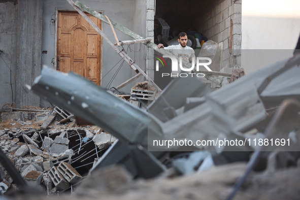 Palestinians inspect the site of an Israeli airstrike on a house amid the ongoing conflict between Israel and Hamas in Al-Maghazi, central G...