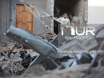 Palestinians inspect the site of an Israeli airstrike on a house amid the ongoing conflict between Israel and Hamas in Al-Maghazi, central G...