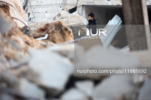 Palestinians inspect the site of an Israeli airstrike on a house amid the ongoing conflict between Israel and Hamas in Al-Maghazi, central G...