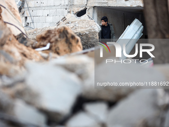 Palestinians inspect the site of an Israeli airstrike on a house amid the ongoing conflict between Israel and Hamas in Al-Maghazi, central G...