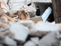 Palestinians inspect the site of an Israeli airstrike on a house amid the ongoing conflict between Israel and Hamas in Al-Maghazi, central G...