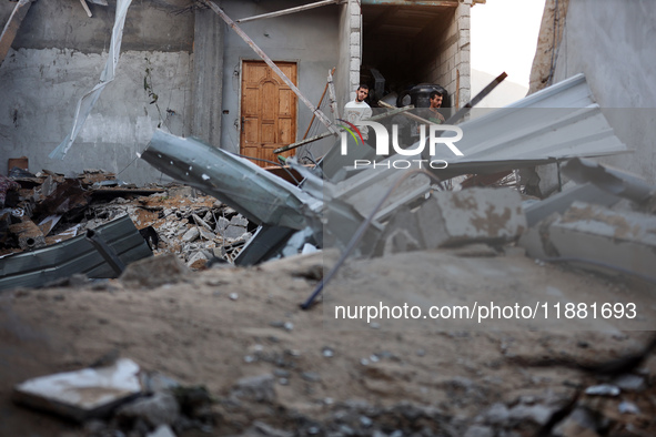 Palestinians inspect the site of an Israeli airstrike on a house amid the ongoing conflict between Israel and Hamas in Al-Maghazi, central G...