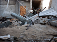 Palestinians inspect the site of an Israeli airstrike on a house amid the ongoing conflict between Israel and Hamas in Al-Maghazi, central G...