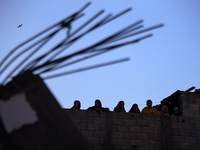 Palestinians inspect the site of an Israeli airstrike on a house amid the ongoing conflict between Israel and Hamas in Al-Maghazi, central G...