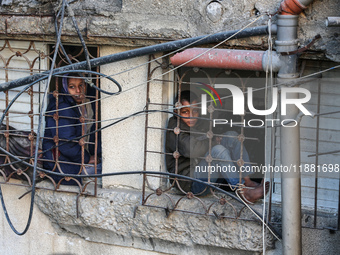 Palestinians inspect the site of an Israeli airstrike on a house amid the ongoing conflict between Israel and Hamas in Al-Maghazi, central G...