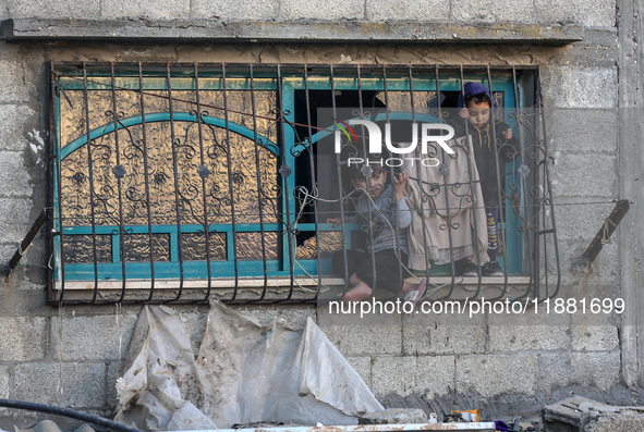 Palestinians inspect the site of an Israeli airstrike on a house amid the ongoing conflict between Israel and Hamas in Al-Maghazi, central G...