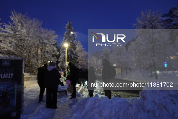 An evening scene occurs at a bus stop in Grainau, Garmisch-Partenkirchen, Bavaria, Germany, on December 13, 2024 