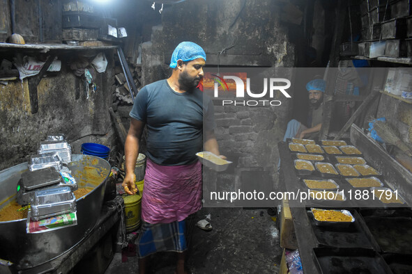 Workers make traditional fruit cake in a wood fire oven at a 100-year-old bakery ahead of Christmas celebrations in Kolkata, India, on Decem...