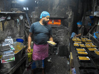 Workers make traditional fruit cake in a wood fire oven at a 100-year-old bakery ahead of Christmas celebrations in Kolkata, India, on Decem...