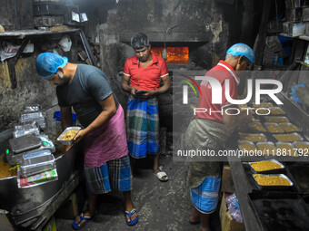 Workers make traditional fruit cake in a wood fire oven at a 100-year-old bakery ahead of Christmas celebrations in Kolkata, India, on Decem...