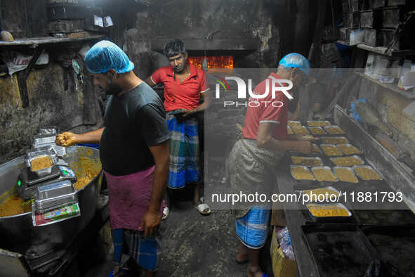 Workers make traditional fruit cake in a wood fire oven at a 100-year-old bakery ahead of Christmas celebrations in Kolkata, India, on Decem...