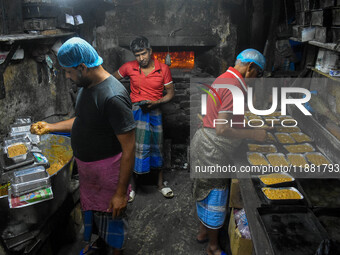 Workers make traditional fruit cake in a wood fire oven at a 100-year-old bakery ahead of Christmas celebrations in Kolkata, India, on Decem...